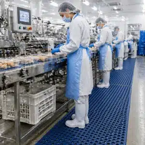 higienske-podloge-za-zivilsko-industrijo-slika-3 Pakirna linija v sodobnem živilskem obratu, kjer higienske podloge za živilsko industrijo zaposlenim zagotavljajo stabilen korak, več udobja pri stanju in varnejše delo ob proizvodni opremi.